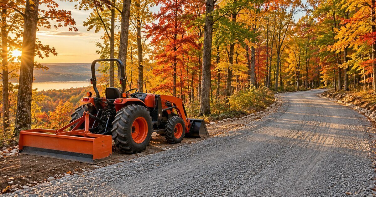 Compact tractor with box blade beside a freshly graded gravel lane on Michigan hunting land
